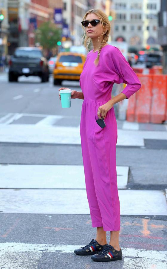 La modelo paseaba así por las calles de Nueva York, con un mono fucsia con zapatillas de Gucci y las gafas de moda. Ella sí que sabe cómo triunfar en el street style.