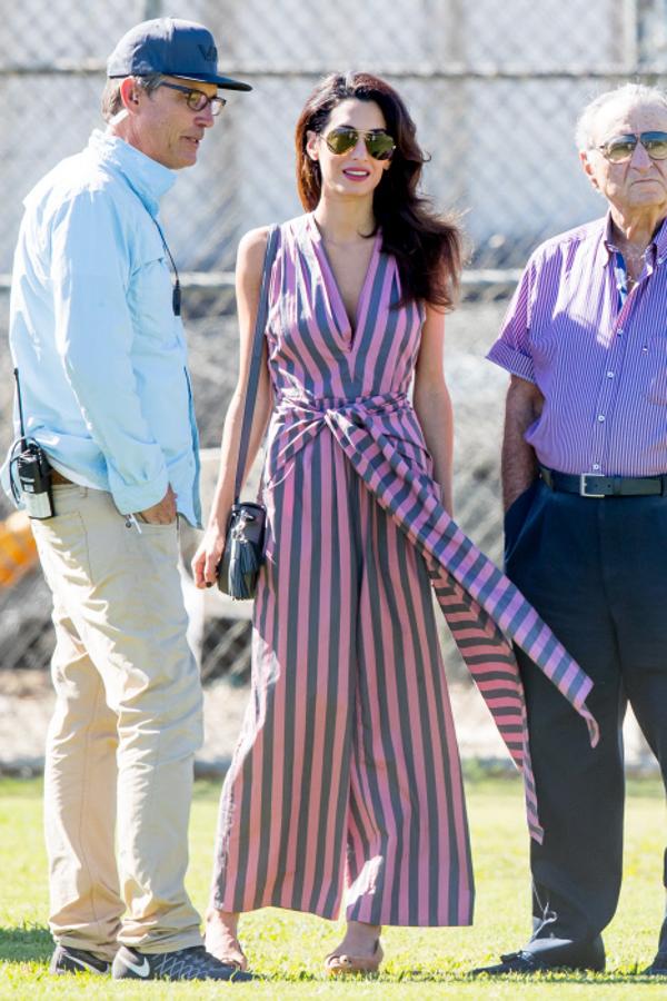 Amal Clooney perfecta con este mono largo de escote en pico y lazo con estampado de rayas. Toda una tendencia esta temporada.