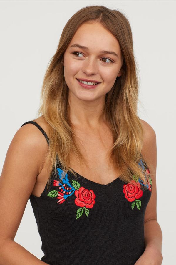 Top corto de punto y con bordado floral, 9,99 euros.