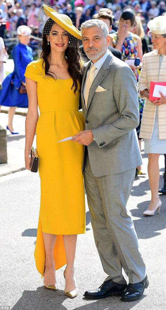 La boda del año. El pasado mes de mayo, los Clooney robaron el foco a los Duques de Cambridge y los Beckham. Fueron los invitados más estilosos en las nupcias de Meghan Markle y Enrique gracias, sobre todo, al estilismo de Amal: un diseño de 'lady' con un toque 'vintage' en vibrante color amarillo miel de Stella McCartney. La pamela de Stephen Jones era perfecta.