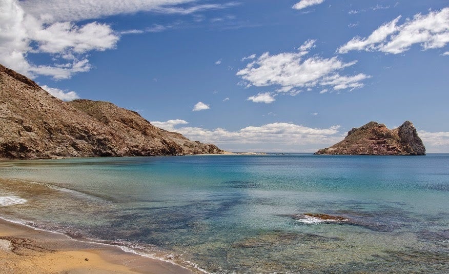 La playa del Hornillo la localizamos en el municipio de Águilas, en Murcia, donde las altas montañas contrastan con el brillante azul del mar en verano. Una playa urbana en la que encontrarás la comodidad de todos los servicios sin romper con la magia de este pequeño rincón paradisíaco.