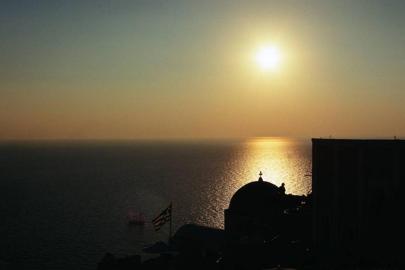 Y llegó el momento de hablar de los atardeceres en Santorini. Porque te aseguramos que una de las experiencias más bonitas que verás nunca tendrá lugar en este rincón de las Islas Cícladas cuando, al caer la tarde, descubras las siluetas de sus casas a contraluz, la inmensidad del sol bañándose en el Mediterráneo, sus blancos y azules plantándole cara a la oscuridad, los ocres que iluminarán todo hasta el último destello y la magia de los mitos y leyendas lo envuelva todo. ¿El lugar más típico para ver el atardecer? Los tejados de Oia.