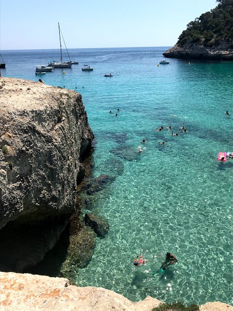 La Cala Mitjana en Menorca está dentro de una de las mejores playas de las Islas Baleares. Un paisaje de postal para fotografiar una y otra y otra vez. En ella podrás nadar en sus aguas transparentes y llegar hasta las cuevas que la bordean. Ideal para estrenar esas gafas de bucear que tienes olvidadas.