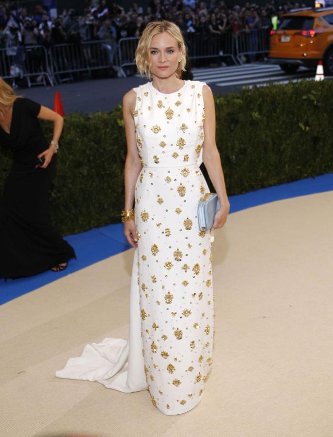 En blanco con aplicaciones doradas, Diane lleva vestido de Prada.