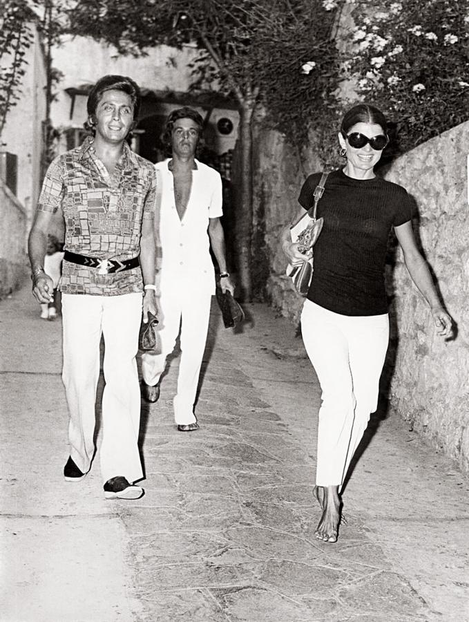 Esta instantánea es mítica. Jackie camina descalza junto a sus amigos, el diseñador Valentino y Giancarlo Giacometti.