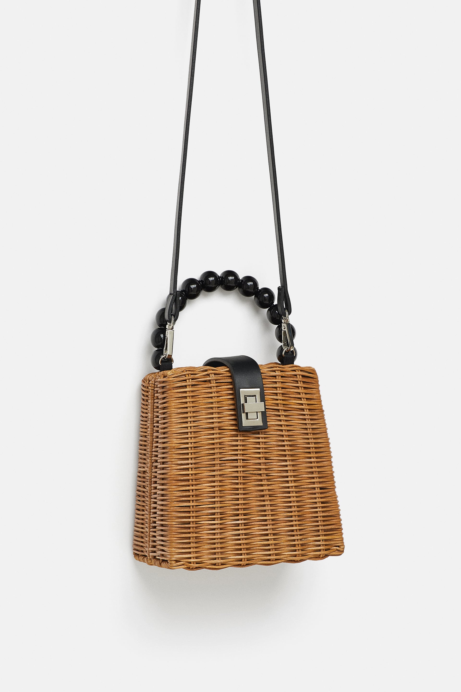 Caja bandolera trenzada con bolas negras de Zara: 29,95 euros.