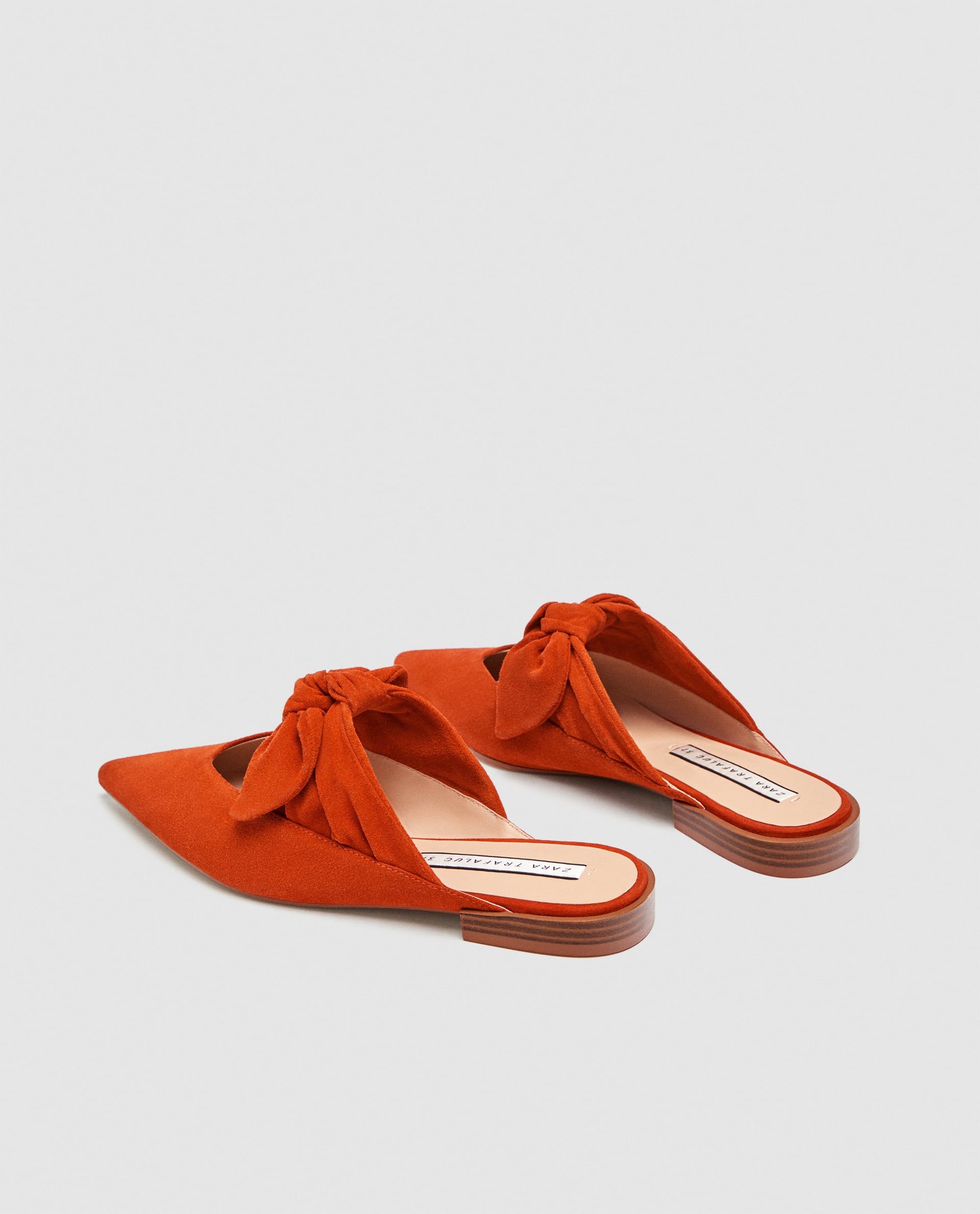 Estilo contemporáneo. Zara propone estos 'mules' color teja y con lazo (de rebajas, 15,99€), para vestidos minimalistas.