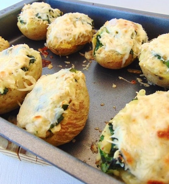 Ingredientes: 4 dientes de ajo, 4 unidades patata, 1 o 2 vasos leche o bebida vegetal, 100 g kale o col rizada, 1 pechuga pollo previamente cocido, 4 cucharadas queso parmesano, aceite de oliva virgen extra, sal al gusto y pimienta negra al gusto. Para su elaboración, introduce las patatas en el microondas para cocinarlas durante 10 minutos. Vacía las patatas y comienza a rellenarlas con el pollo y el kale ya cocinado. Echa tres cucharadas de aceite de oliva y espolvorea con parmesano. Introduce al horno y deja que se gratinen.