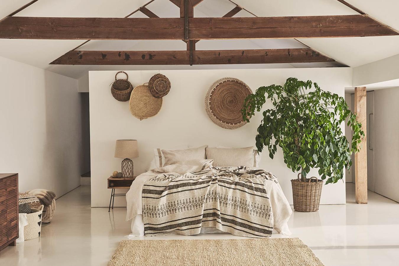 La pureza de líneas y los elementos textiles en materiales rústicos y colores neutros se unen a la madera para dar forma a un dormitorio tan cálido y acogedor como este.