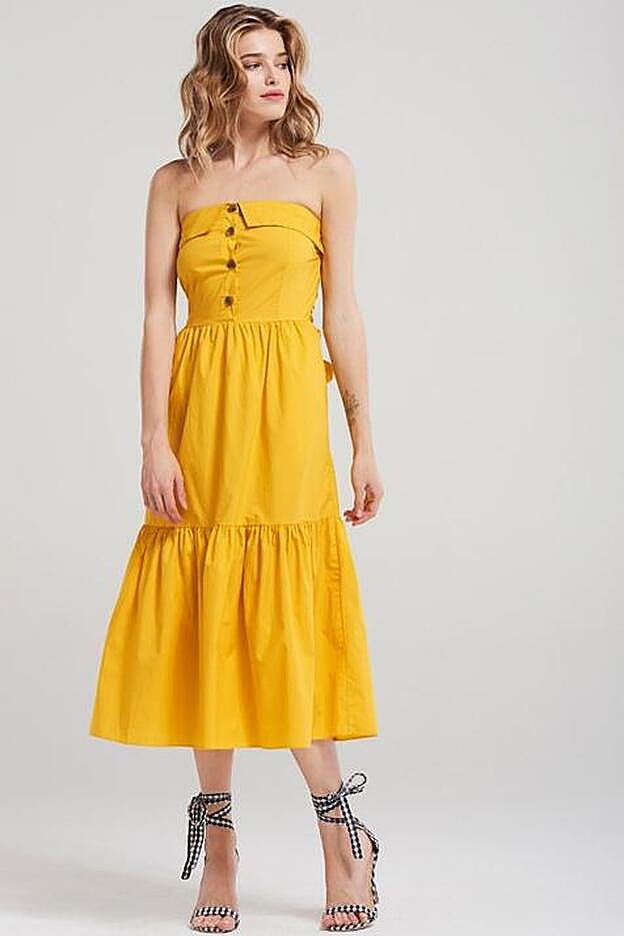 Vestido largo en color amarillo con maxi volante en el bajo y escote off-shoulder, 76,55 euros.