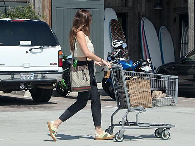 La actriz se decantó por un top cropped lencero, pantalones tobilleros negros y zapatillas deportivas con bolso a juego de Gucci.