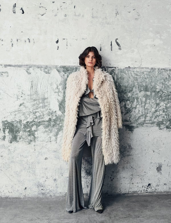 Nuria Rothschild luce conjunto de camisa, sujetador y pantalón de punto de Nina Ricci. Los zapatos son de la misma firma. El abrigo es de Mirto y los pendientes, de Pretty Rumor.