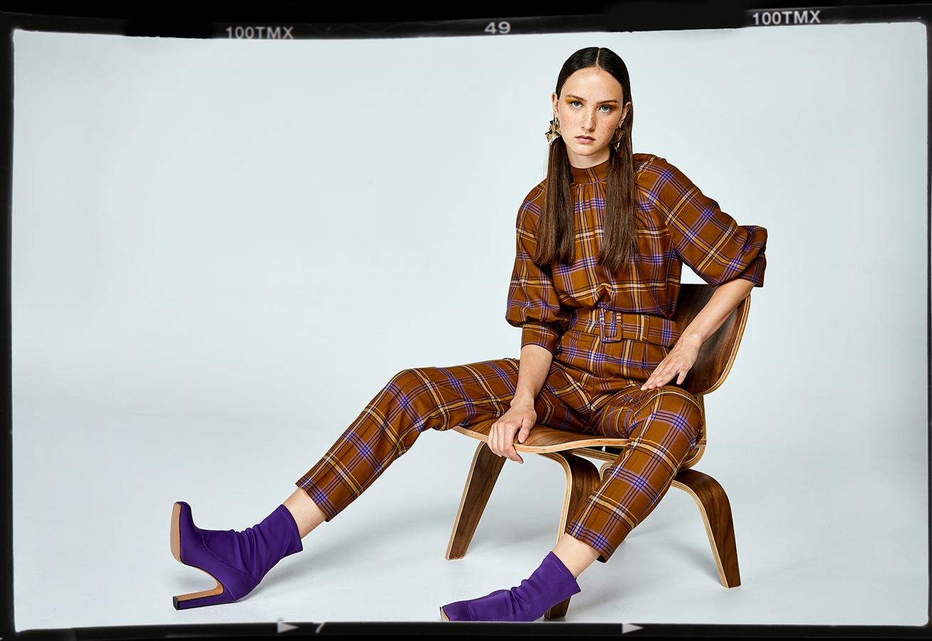 Original dos piezas de inspiración setentero en marrón chocolate con estampado tartán en morado y mostaza de Sfera. El cuerpo cuesta 35.99 euros, y el pantalón, 29.99 euros.