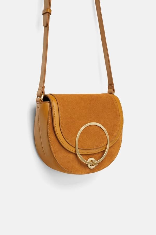 Este bolso nos recuerda a uno de la nueva colección de Chloé, que es de cuero y en tono nude. Zara lo tiene en mostaza y ante. Precio: 29,95 euros.