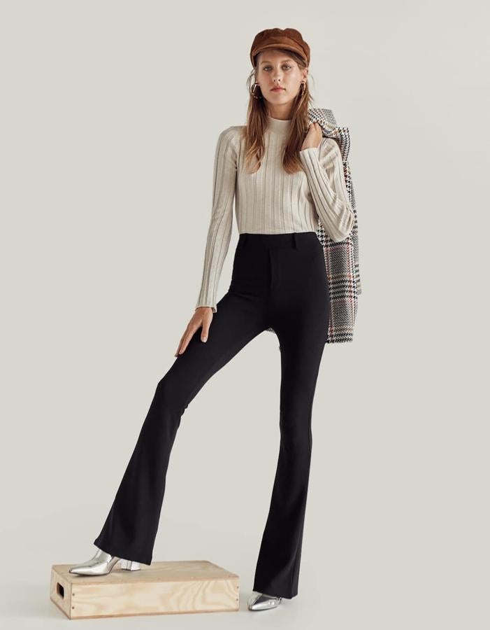 Pantalón 'flare' de punto liso en color negro, 19,99 euros.