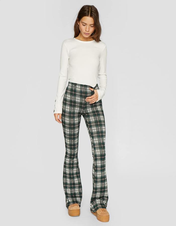 Pantalón 'flare' de punto con estampado de cuadros en color verde botella, 19,99 euros.