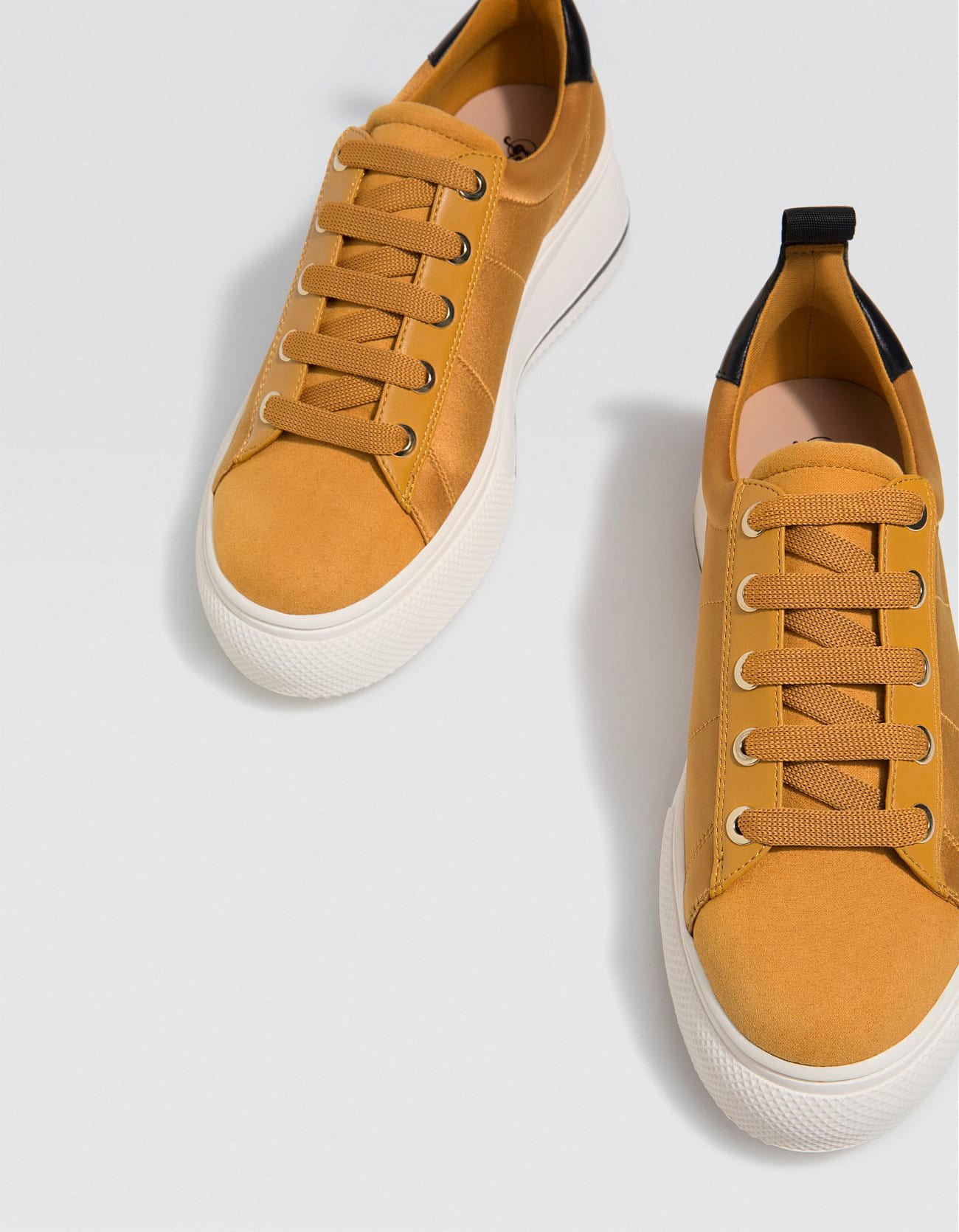 Deportivas con plataforma en color mostaza de Stradivarius: 19,99 euros.