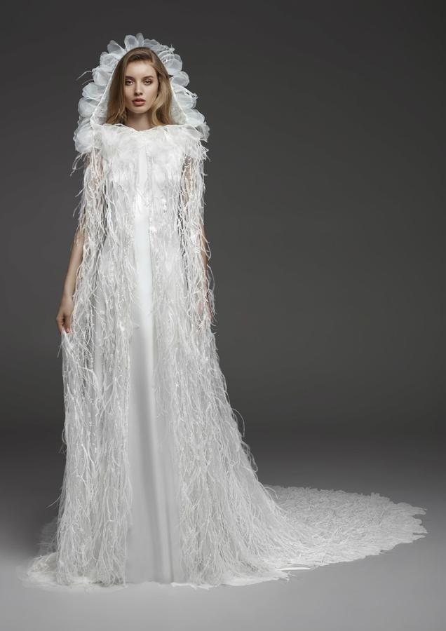 Nos fascina este vestido de novia con capa de plumas y capucha fantasía.