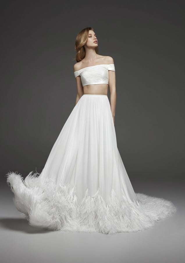 Dos piezas con 'crop top' de escote Bardot y falda terminada en plumas, de Pronovias Atelier.