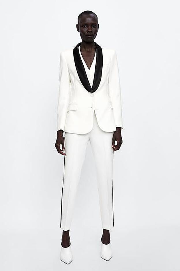 Traje smoking con cuello solapa a contraste, manga larga y detalle de banda lateral en el pantalón.