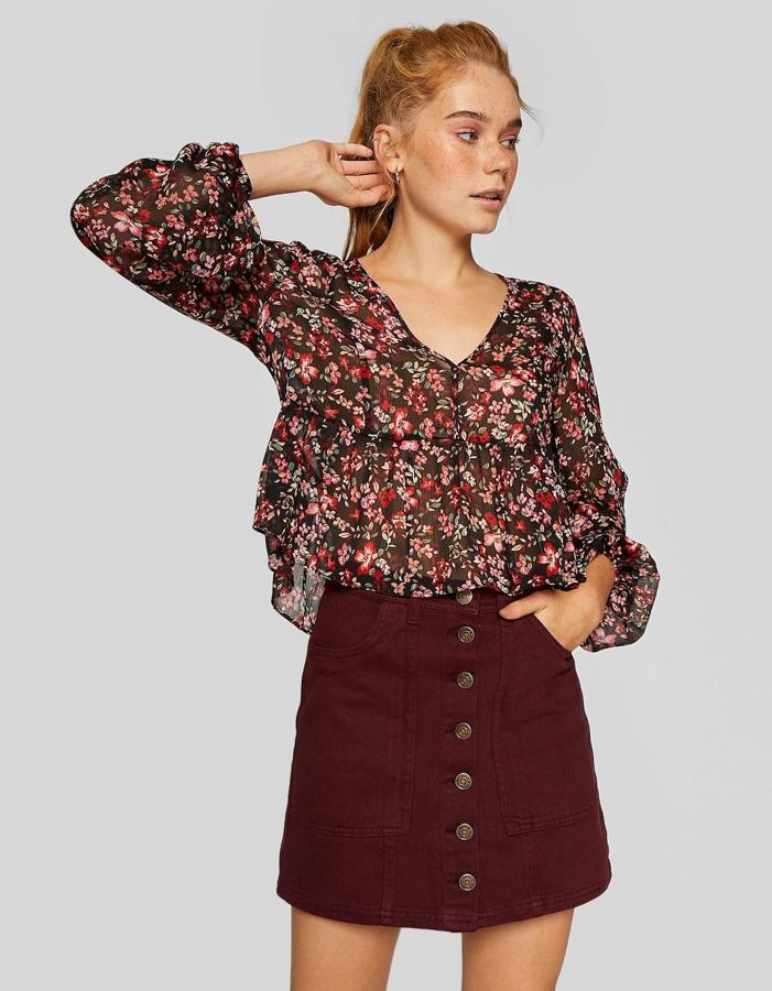 El color burdeos es la clave de este precioso estilismo con un punto romántico: falda línea A con botones (17,99 euros) y blusa de flores con peplum (17,99 euros).