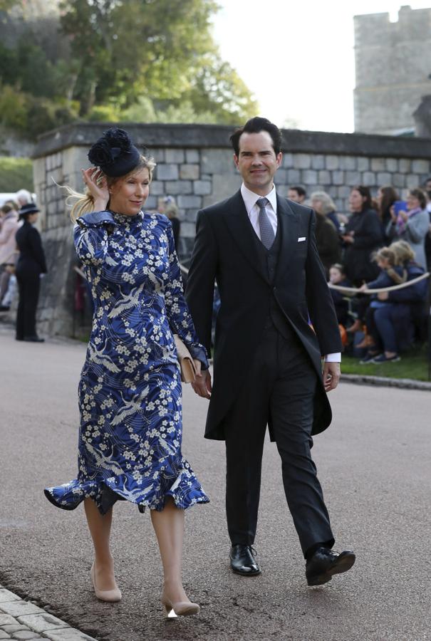 Jimmy Carr en su llegada al castillo de Windsor junto a su novia Karoline Copping que nos ha encantadosu vestido estampado en tonos azules.Como la mayoría de las invitadas, ella también tuvo que sujetar su tocado par que no se lo llevara el viento.