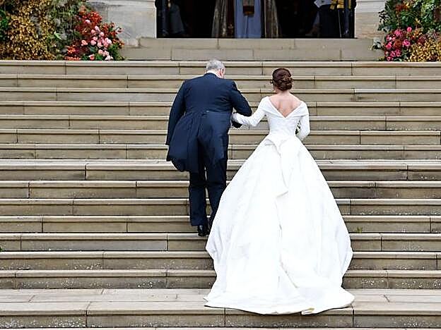 Eugenia de York junto a su padre Andrés subiendo las escaleras de la capilla.