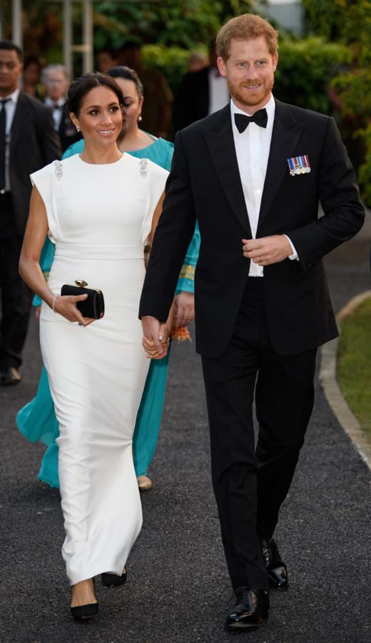 En la cena de gala ofrecida por el Rey Tupou VI de Tonga y la Reina Nanasipau’u, Meghan Markle 'ha vuelto a vestirse de novia' con un impresionante vestido blanco con detalles joya de Theia Couture que ha combinado con clutch de Givenchy, salones de Aquazzura y, casi a la vez que  Kate Middleton lucía la tiara favorita de Lady Di , la Duquesa de Sussex apostaba por el anillo de aguamarinas que perteneció a la Princesa Diana.