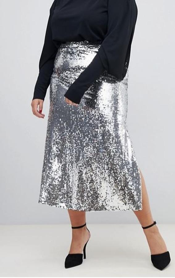 En un tono más discreto, aunque el plateado integral no deja de ser un foco de atención innegable, tenemos esta falda midi en línea evasé de Neon Rose Plus (62,99 euros). Con una sudadera negra, impecable.