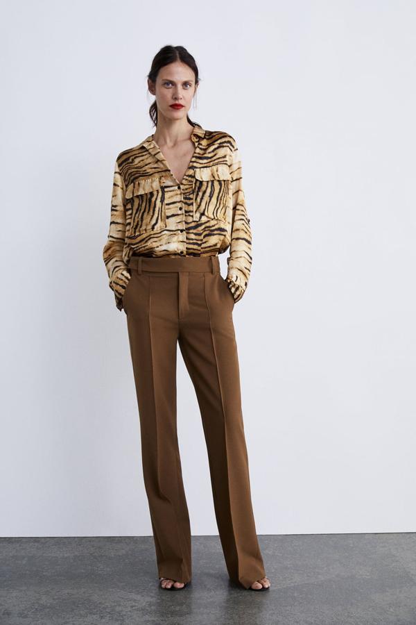 Este look de los estilistas de Zara parece sacado de una colección de la añorada Phoebe Philo para Céline: no puede ser más retro ni más chic. La blusa con un estampado animal realista (29,95 euros) y el pantalón flare (39,95 euros) derrochan estilo.