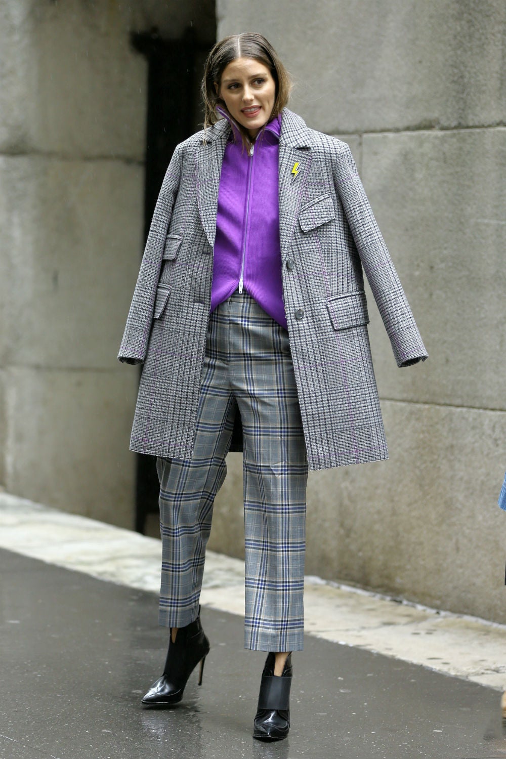 Olivia Palermo lució este look en la Semana de la Moda de Nueva York y quiso combinar su abrigo de paño gris con unos pantalones del estilo. Además, ella también prefiere poner complementos a sus prendas y ha añadido un pin con forma de rayo.