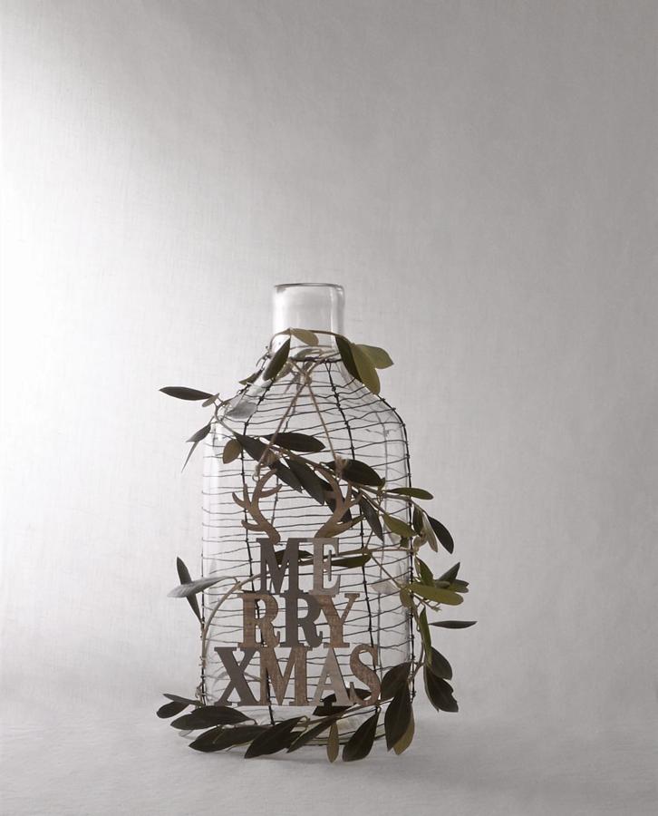 Otra idea muy original para montar un 'árbol de Navidad' diferente en cualquier rincón. Esta botella 'Merry Xmas' (39.95 euros) decorada con hojas de olivo nos parece una idea genial para vestir de fiesta tu mesa en la oficina.