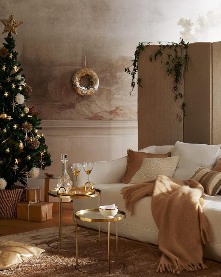 Un saalón clásico necesita un árbol de Navidad clásico como este, decorado en tonos dorados y con un plus de calidez.