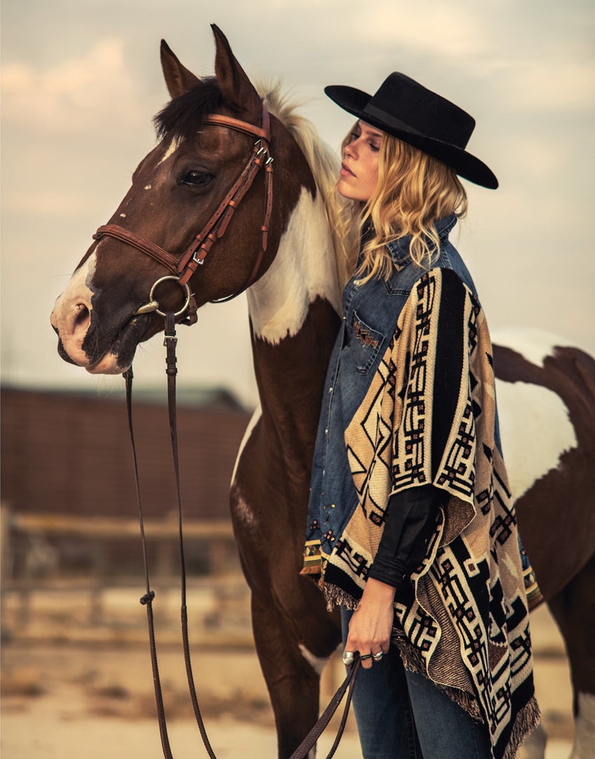 Poncho en denim y punto de Desigual; vaquero de Easy Wear y camisa de Elogy, ambos para El Corte Inglés; anillos de Aristocrazy; y sombrero de Sendra.