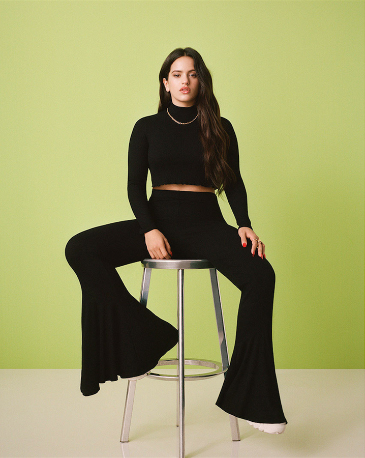 El único toque flamenco de la colección: unos pantalones campana confeccionados en tejido elástico negro (19,99 euros), que Rosalía combina con una camiseta corta de manga larga (14,99 euros). Imponente.