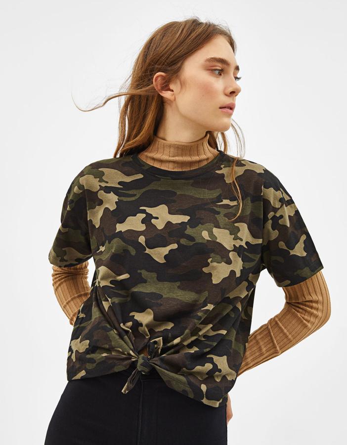 Qué gran idea quitarle hierro militar a una camiseta básica con estampado "camo" (7,99 euros) gracias a un nudo híper femenino.