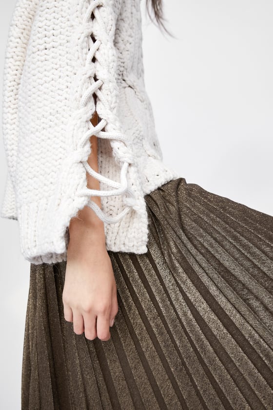 Jersey de ochos y trenzas con aberturas en las mangas de Zara. (29,95 euros).