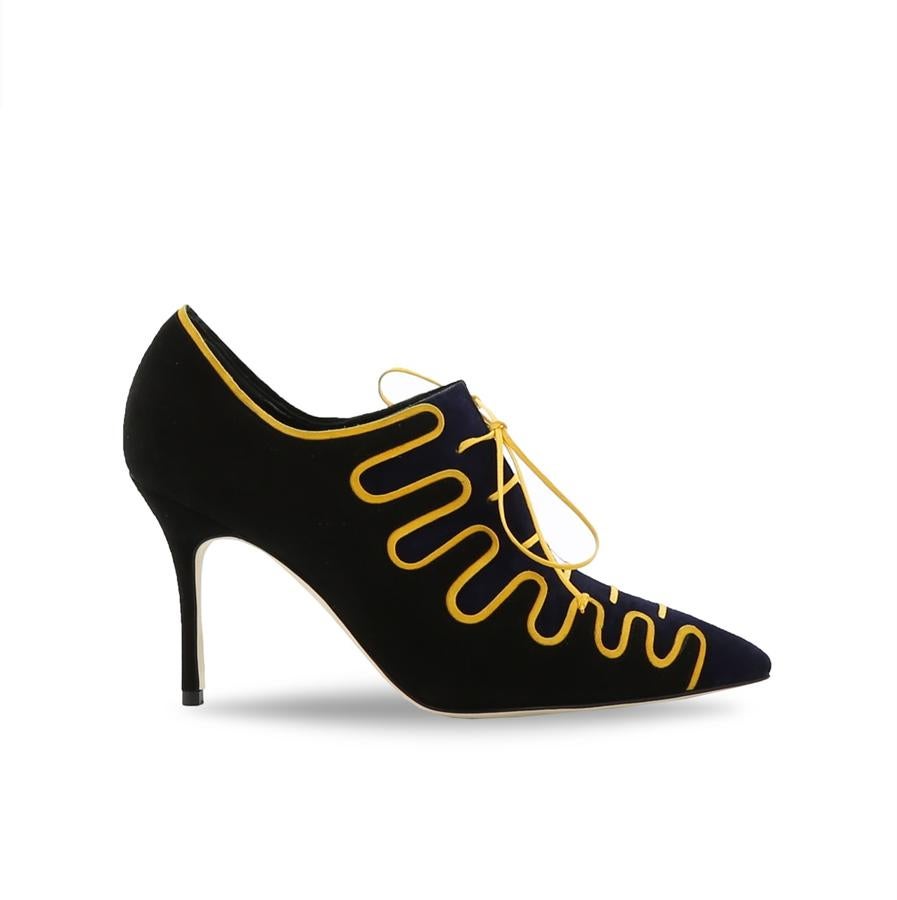 Manolo Blahnik: zapato cerrado de tacón con cordones amarillos.