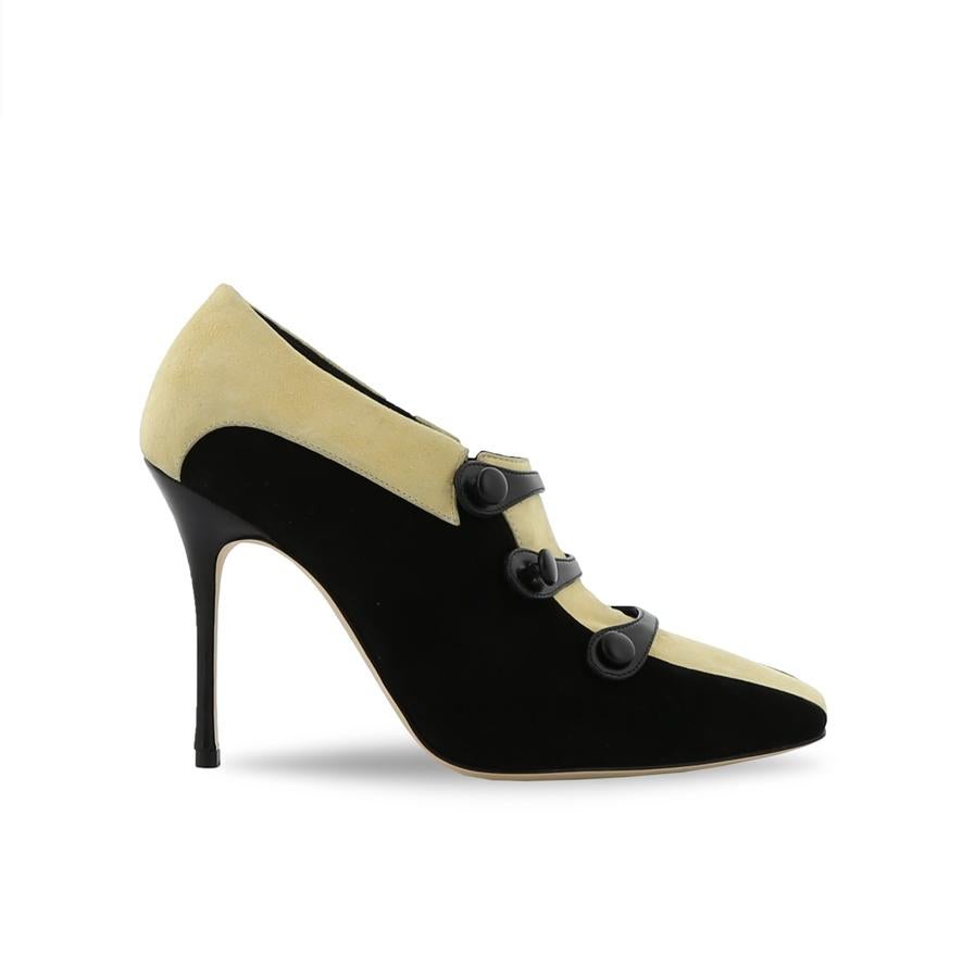 Manolo Blahnik: zapato cerrado de tacón morado con botonadura en el empeine.