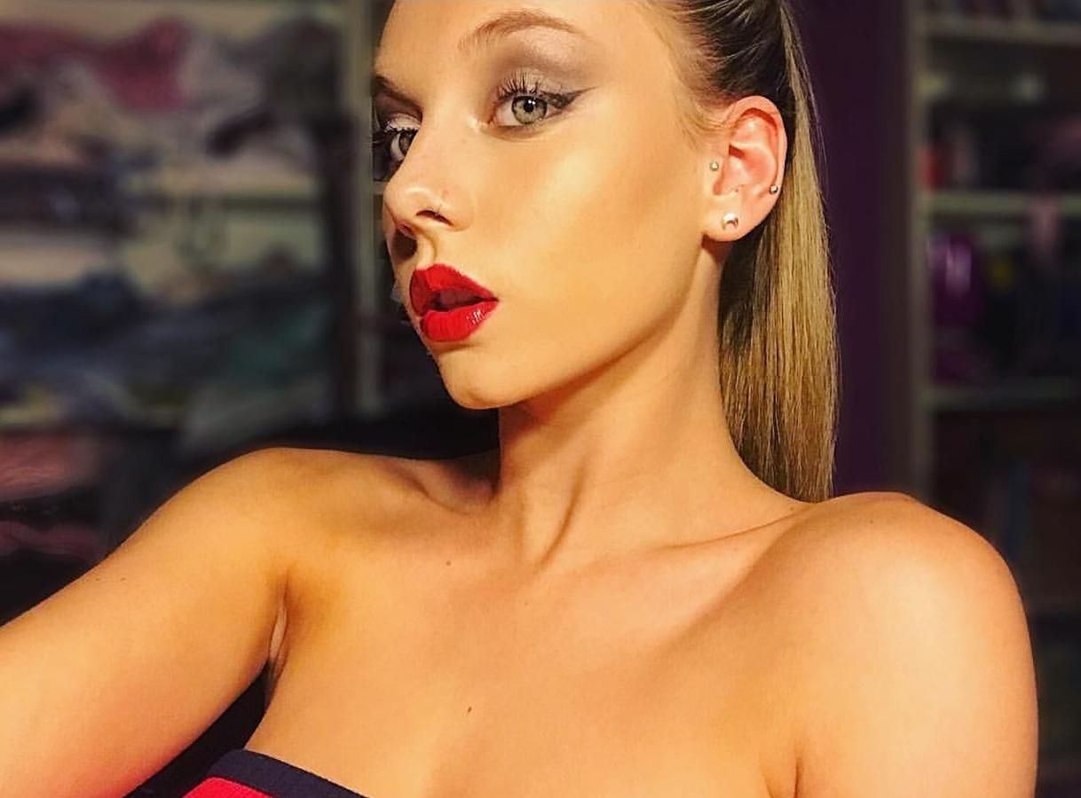 La combinación de labial rojo intenso y eyeliner es la clara ganadora en nuestros maquillajes de fiesta. Ester Expósito le añade un toque de sombra plateada en el párpado móvil, bien de iluminador y un toque 'glossy' a sus labios obteniendo un maquillaje final súper sexy.