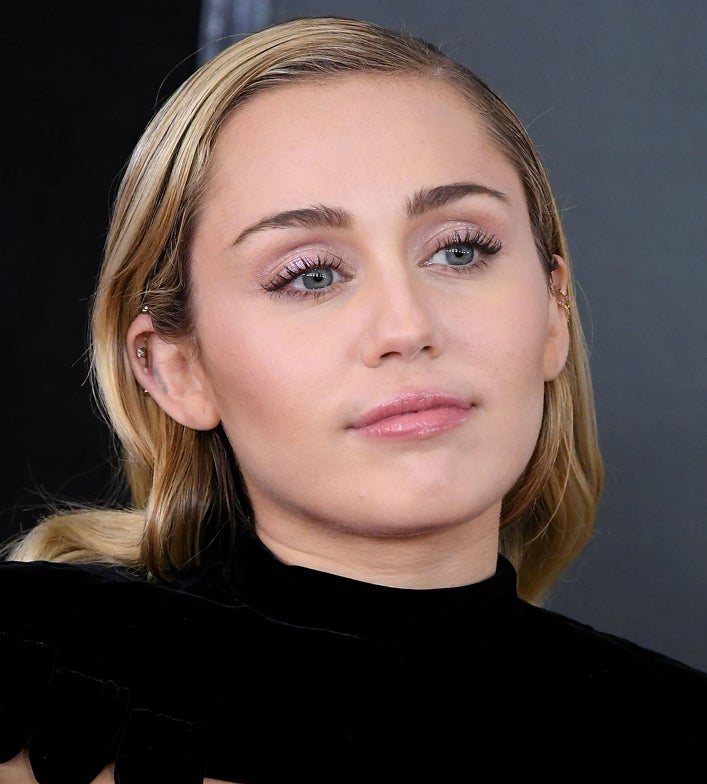 Miley Cyrus tiene una piel impoluta: sin imperfecciones, sin rojeces, sin granitos. Eso le hace mucho más fácil lucir un maquillaje natural con un poco de brillo en los labios, sombra glitter de un color pastel y un ligero toque de máscara de pestañas. En este caso el protagonismo se lo lleva el peinado efecto wet que tanto nos gusta.