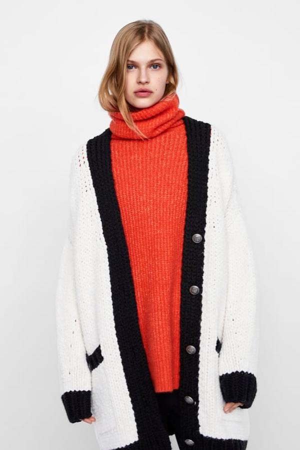 Chaqueta "oversize" blanca de cuello redondo y escote en pico, con acabados en contraste de negro (Zara, 39,95 euros)..