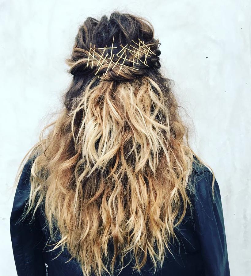 Olvídate de esconder las horquillas para que no se vean sobre tu pelo y decora con ellas tu semirecogido. Coge dos mechones de la parte superior de las orejas, retuércelos ligeramente (dos vueltas son suficientes) y sujétalos cruzando varias horquillas en la parte trasera.