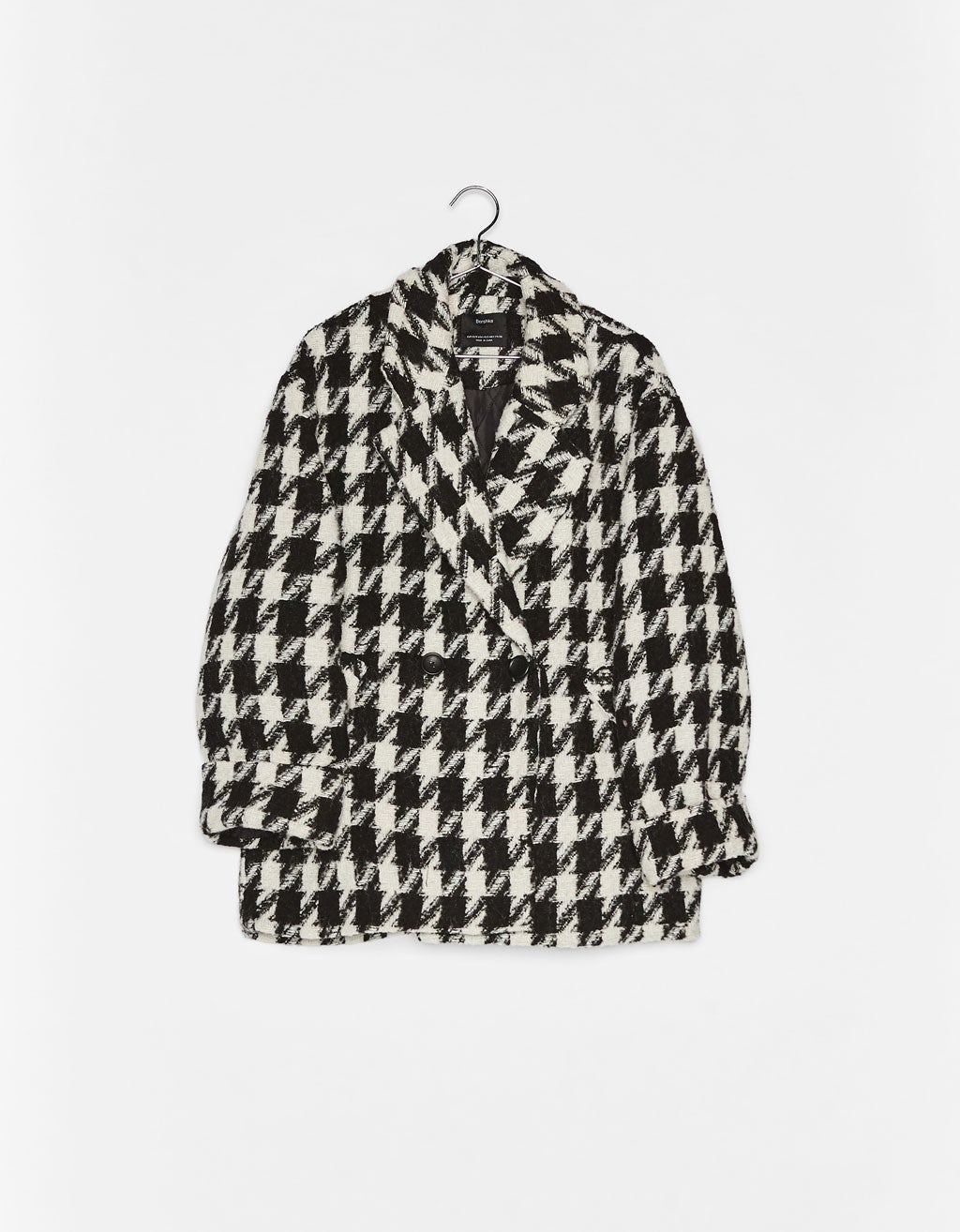 Abrigo cruzado con estampado de pata de gallo. En Bershka por 49,99 euros.