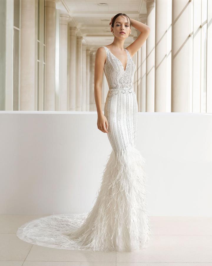 Nos imaginamos a Elena Tablada con un vestido de novia sugerente, pero muy sofisticado, con detalles joya, escotazo y plumas, como si el camino al altar fuera una glamourosa alfombra roja. El de la foto es de Rosa Clará Soft.