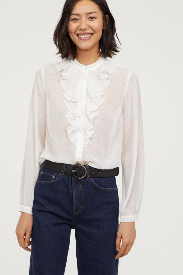 Blusa en tejido vaporoso con volante delante, con botones ocultos en la parte delantera, puños finos con botón y bajo ligeramente redondeado (H&M, 24,99 euros).