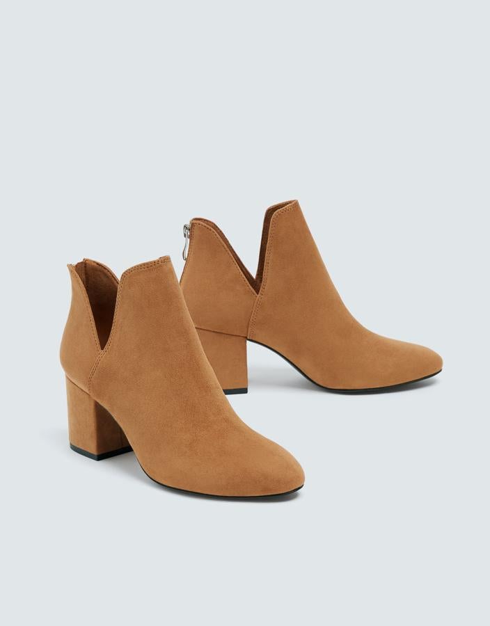 Estos botines de Pull&Bear también tienen el tobillo abierto y, por si no fuera suficiente para alargar nuestras piernas, su tono beige también ayuda. Precio: 25.99 euros.