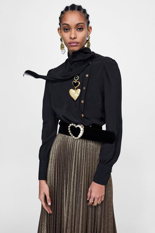 Esta blusa negra con botones dorados en contraste cuesta casi 70 euros, así que necesitamos que tenga un buen descuento en las próximas rebajas de Zara.