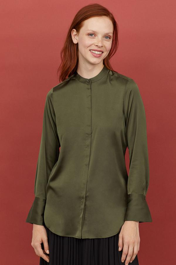 Blusa en un color verde oscuro con puños XXL con abertura y botón, bajo redondeado y cuello elevado (H&M, 11,99 euros).