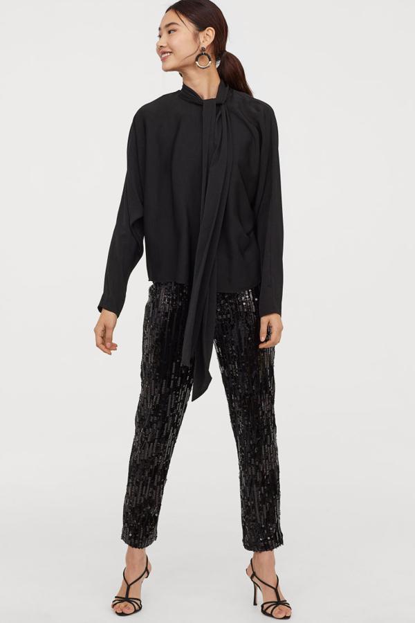 Blusa de satén con lazo alrededor del cuello, cierre de lágrima con corchete en la nuca y mangas dolman (H&M, 23,99 euros).